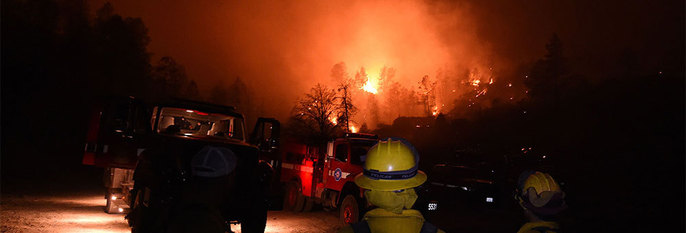  BRANN:  Det brenner i skogen i USA. Mange hus er ødelagte. Brannfolk jobber hardt med å slokke brannen.