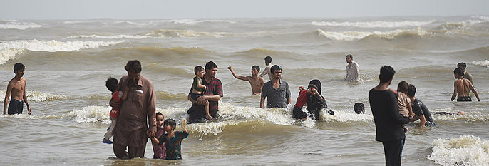  VARMT:  Folk kjøler seg ned på en strand i Pakistan. 700 personen har dødd i en hetebølge.